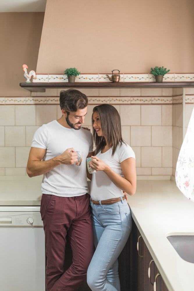 Unmarried couple standing together in a kitchen